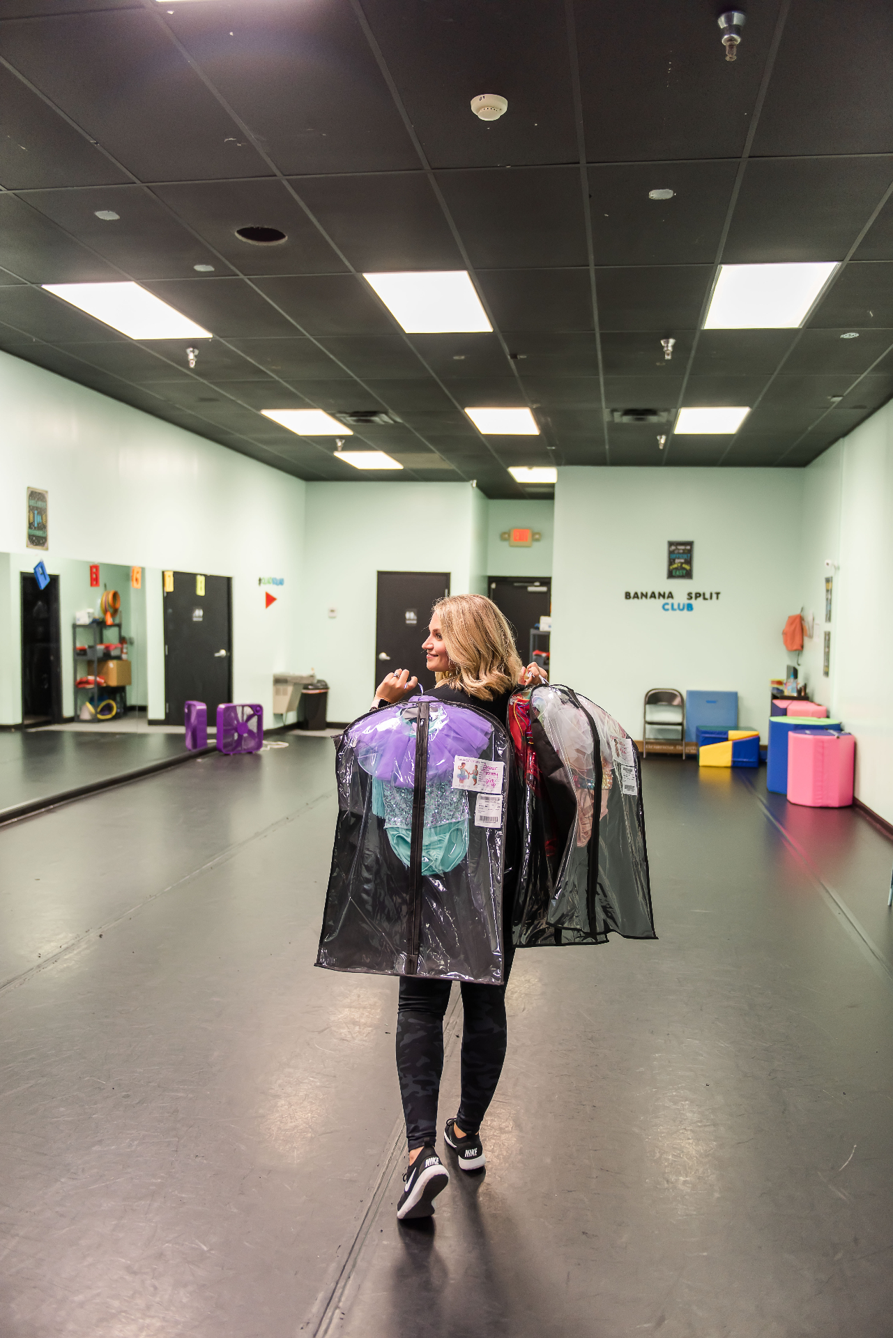 Cameron Ligon carrying costumes in her dance studio